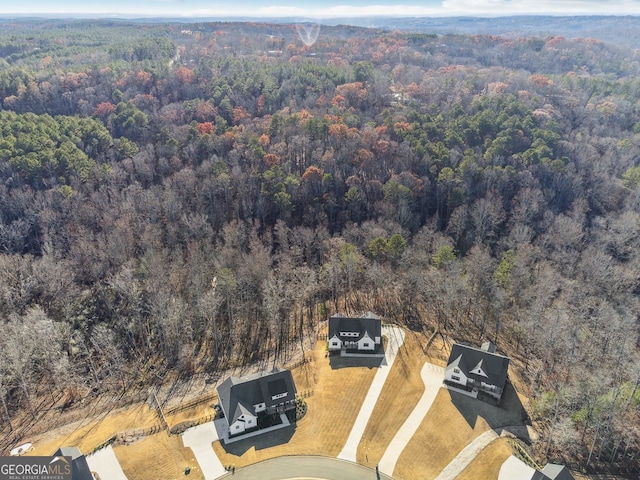 drone / aerial view with a wooded view