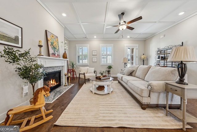 living room featuring dark wood finished floors, a premium fireplace, recessed lighting, coffered ceiling, and a ceiling fan