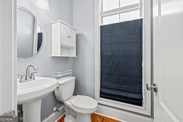 bathroom with toilet, wood-type flooring, and sink