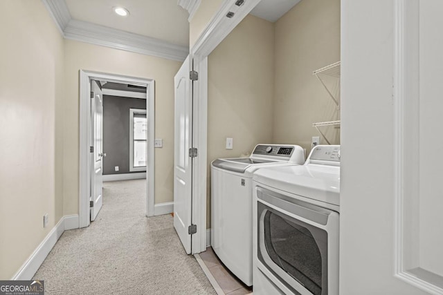 laundry area featuring crown molding, light carpet, and washing machine and clothes dryer