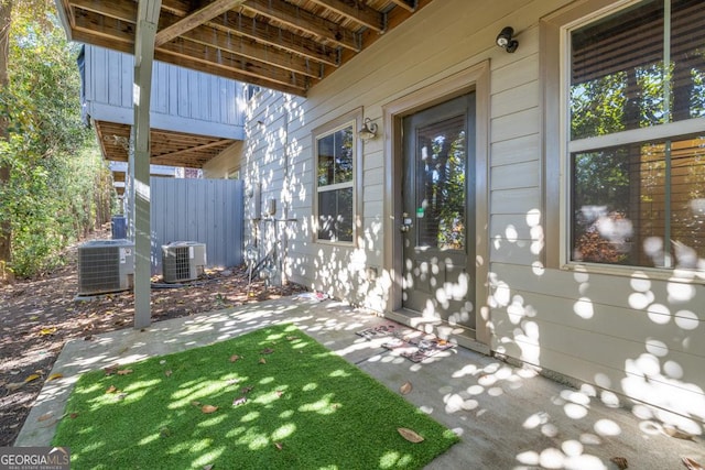 view of exterior entry with cooling unit and a patio area