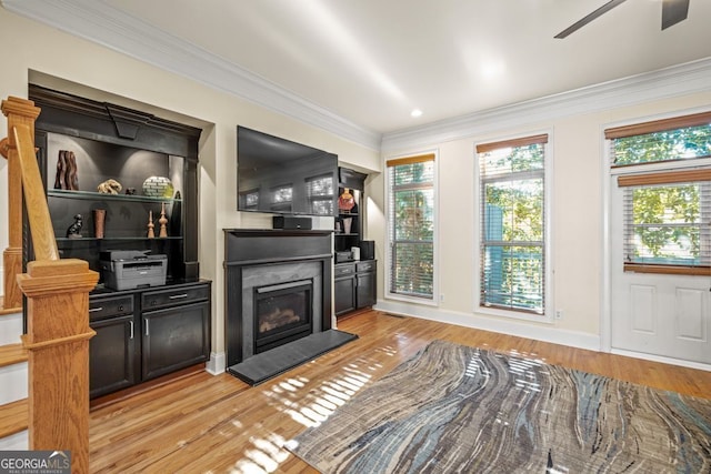 living room featuring light wood-type flooring, ceiling fan, and ornamental molding