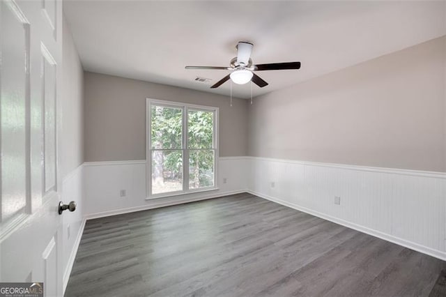 unfurnished room with ceiling fan and dark wood-type flooring