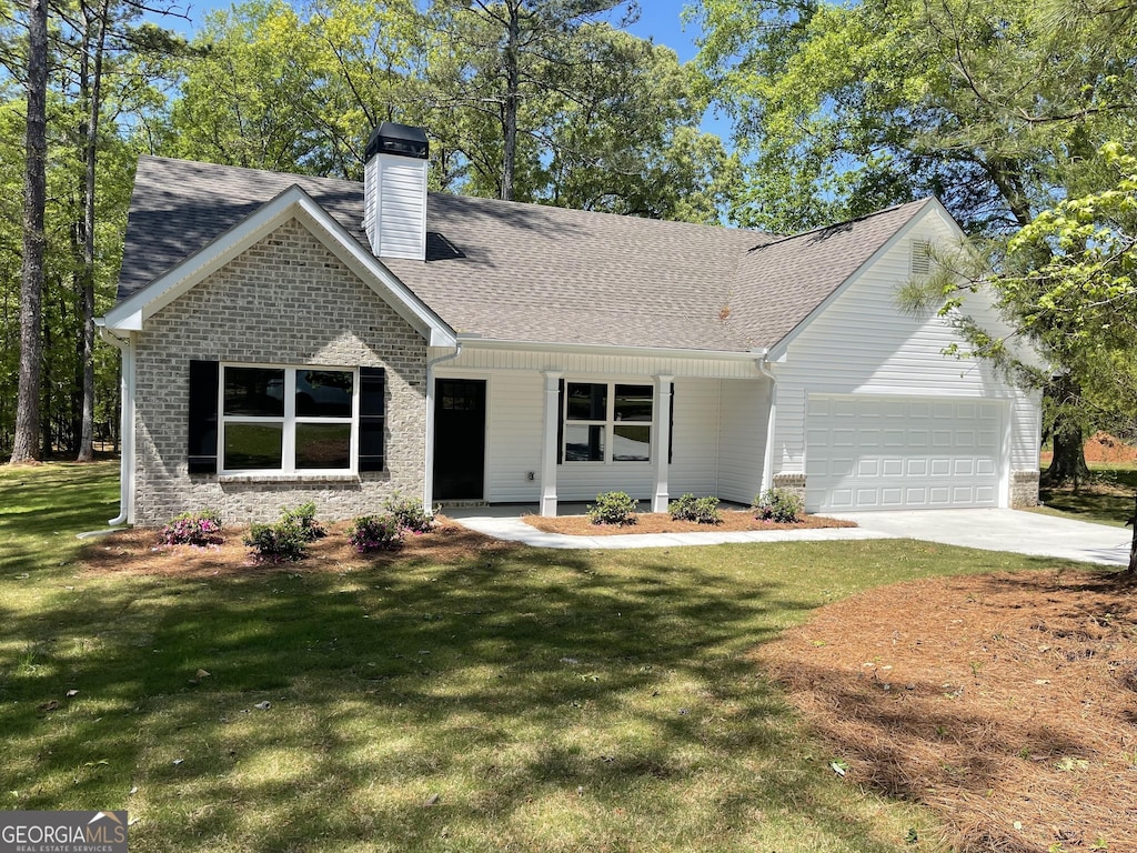 156 Coffey Rd, Barnesville, GA 30204 - view of front facade with concrete driveway, a front lawn, a garage, and a chimney