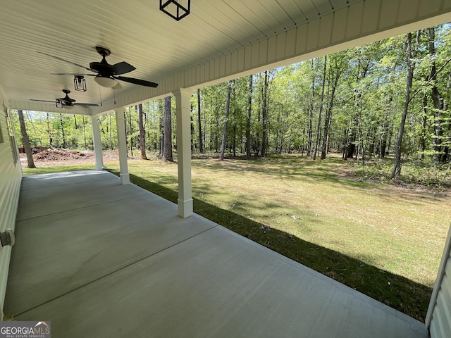 view of patio / terrace featuring ceiling fan and a forest view