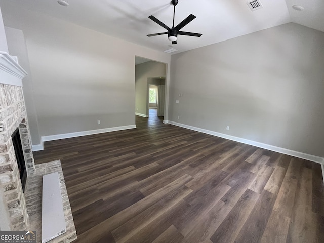 unfurnished living room featuring a fireplace, visible vents, dark wood finished floors, and ceiling fan