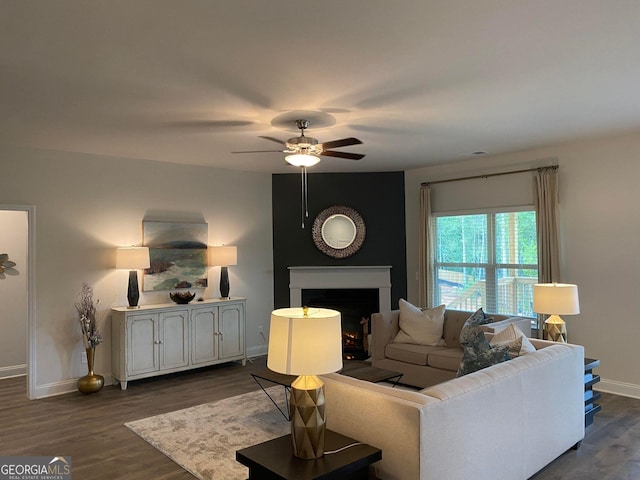 living room with ceiling fan and dark wood-type flooring