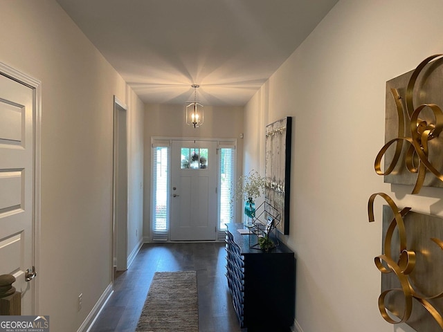 foyer entrance featuring dark hardwood / wood-style floors and an inviting chandelier