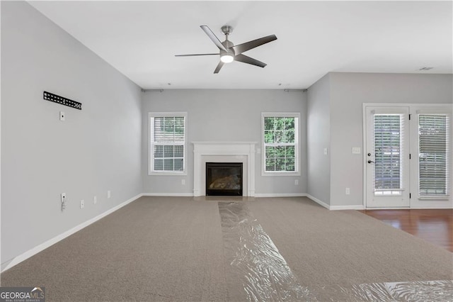 unfurnished living room featuring carpet and ceiling fan