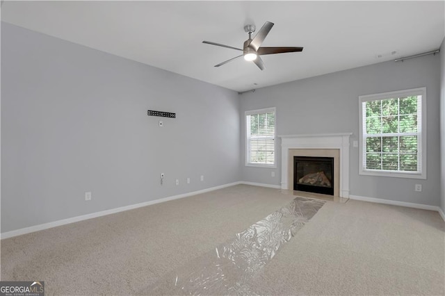 unfurnished living room featuring light carpet and ceiling fan