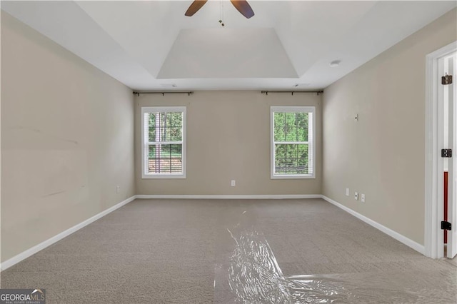 empty room with carpet flooring, ceiling fan, and a wealth of natural light