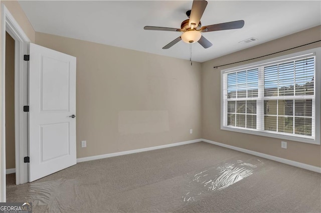 unfurnished room with ceiling fan and light colored carpet