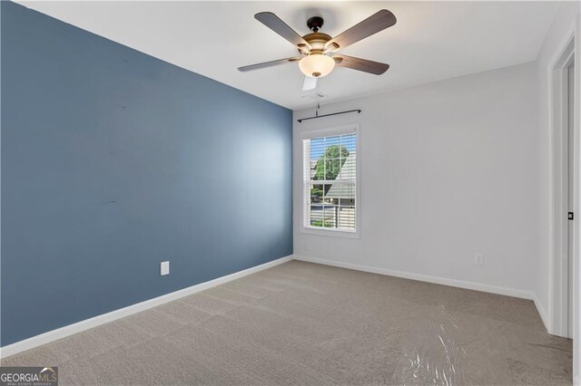 carpeted empty room featuring ceiling fan