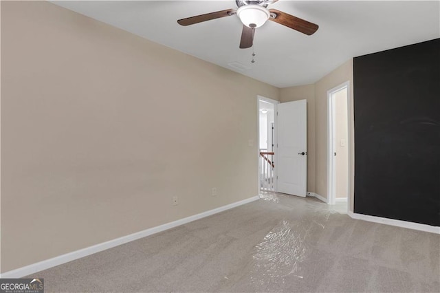 spare room featuring ceiling fan and light colored carpet