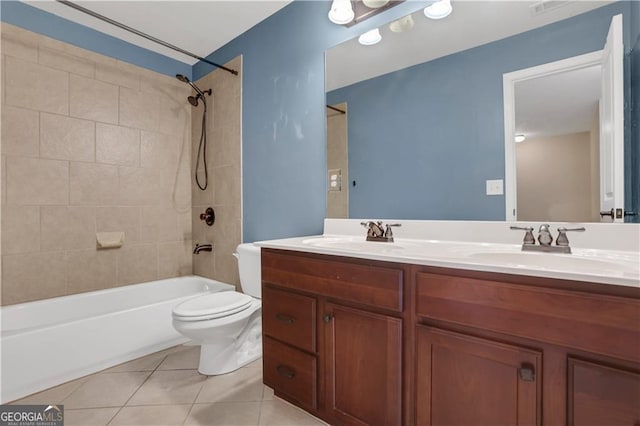 full bathroom featuring tile patterned flooring, tiled shower / bath combo, toilet, and vanity