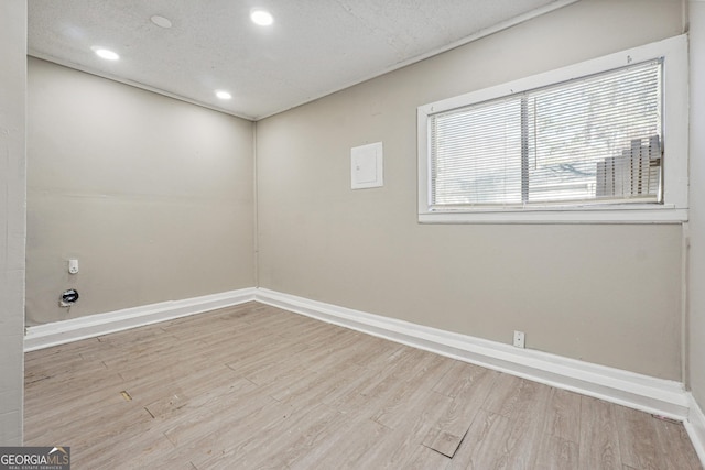 spare room featuring a textured ceiling and light hardwood / wood-style flooring