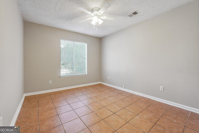 tiled spare room with ceiling fan and a textured ceiling