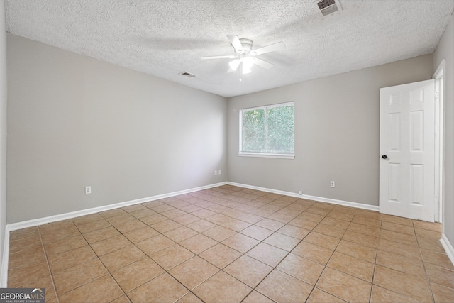 unfurnished room with ceiling fan, light tile patterned floors, and a textured ceiling