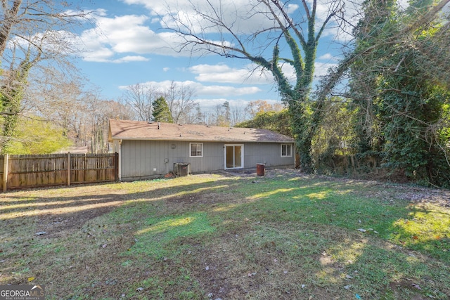 rear view of property with a lawn and cooling unit