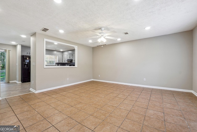 tiled spare room featuring ceiling fan and a textured ceiling