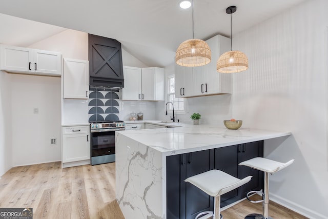 kitchen with decorative light fixtures, white cabinetry, and stainless steel stove