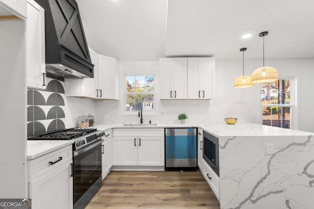 kitchen featuring stainless steel appliances, white cabinetry, custom exhaust hood, and sink