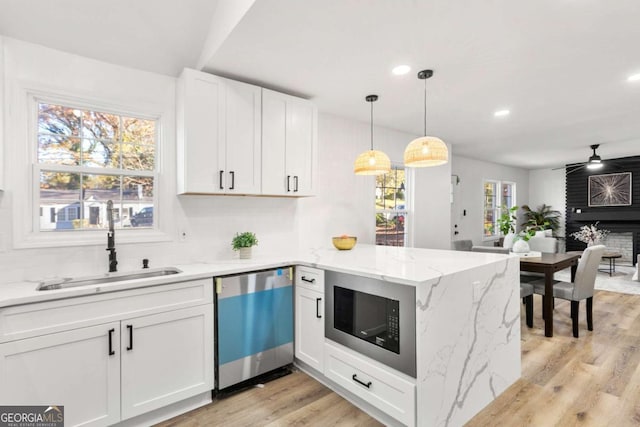 kitchen featuring stainless steel dishwasher, white cabinets, kitchen peninsula, and built in microwave