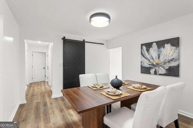 dining room featuring a barn door and wood-type flooring