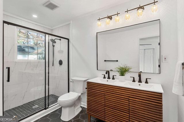 bathroom featuring toilet, vanity, tile patterned floors, and a shower with door