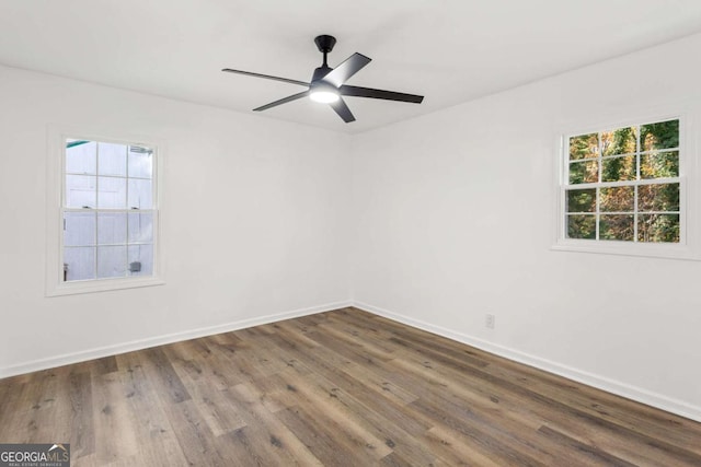 unfurnished room featuring dark hardwood / wood-style floors, ceiling fan, and a healthy amount of sunlight