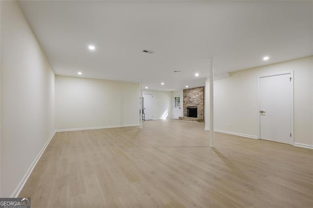 unfurnished living room with light wood-type flooring, a fireplace, and recessed lighting