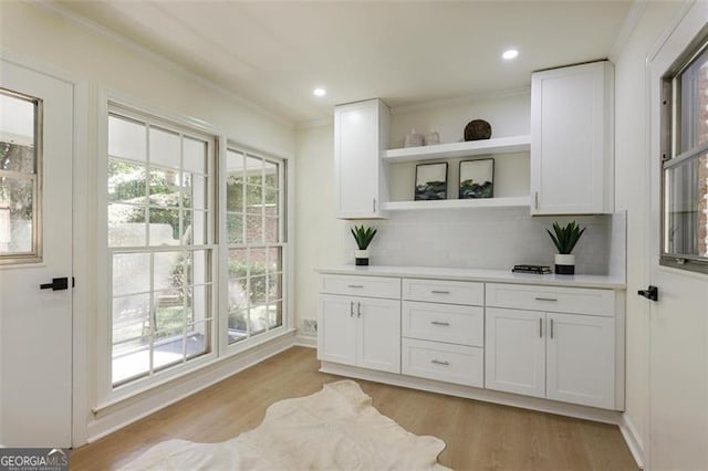 bar featuring crown molding, tasteful backsplash, recessed lighting, light wood-style floors, and baseboards