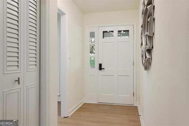 doorway featuring light wood finished floors and baseboards