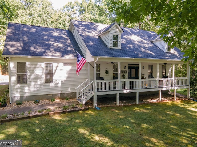 new england style home featuring covered porch, ceiling fan, and a front yard