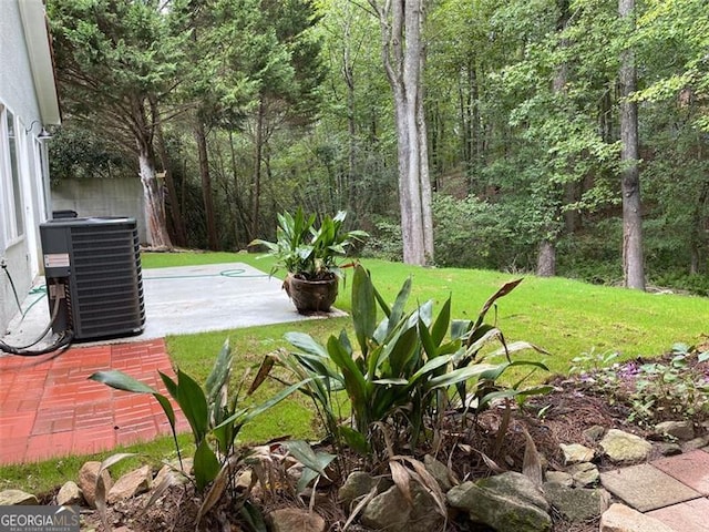 view of yard featuring central air condition unit and a patio area