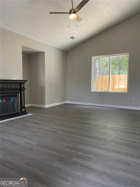 unfurnished living room featuring dark hardwood / wood-style floors, ceiling fan, lofted ceiling, and a textured ceiling