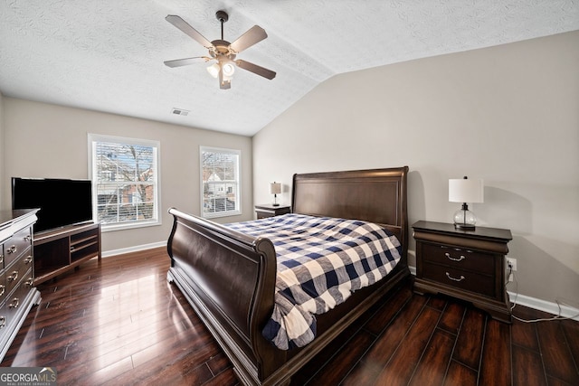 bedroom with a textured ceiling, dark hardwood / wood-style flooring, ceiling fan, and lofted ceiling