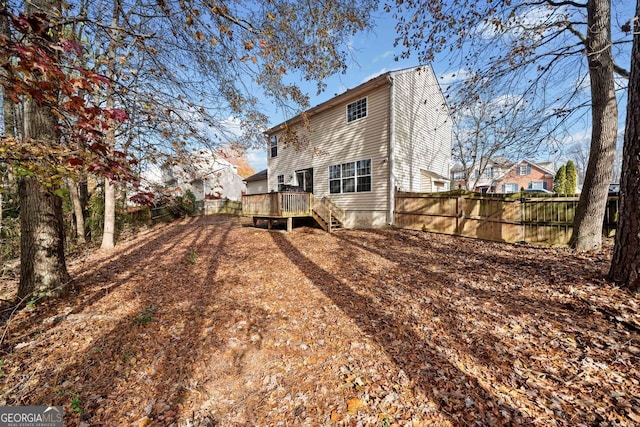 rear view of property featuring a wooden deck