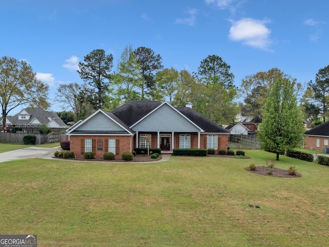 view of front of home featuring brick siding, concrete driveway, fence, and a front lawn