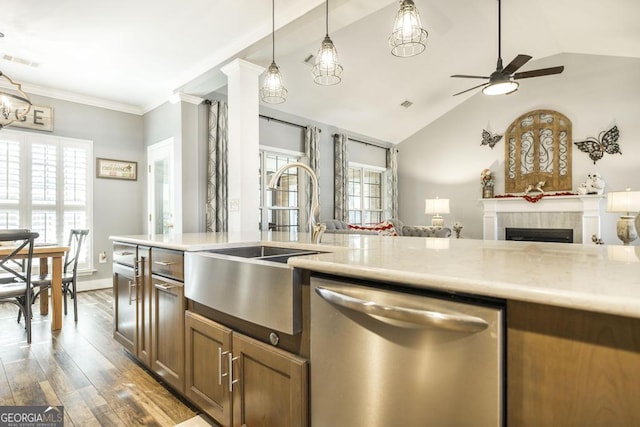 kitchen with dark hardwood / wood-style flooring, a fireplace, vaulted ceiling, sink, and dishwasher