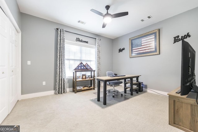 carpeted office space featuring ceiling fan