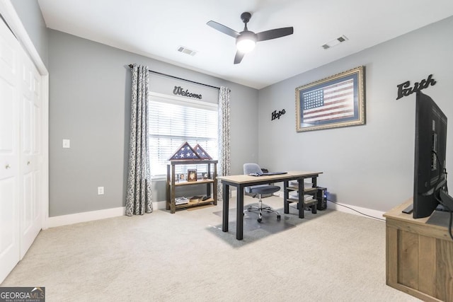 carpeted office with a ceiling fan and baseboards