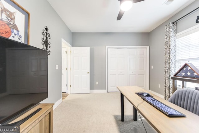 carpeted office space featuring ceiling fan