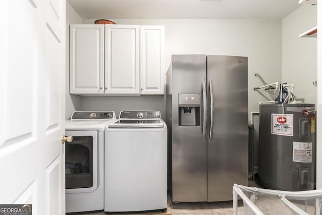 laundry area featuring washing machine and clothes dryer, electric water heater, light tile patterned floors, and cabinets