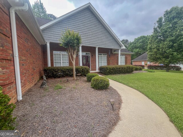 view of front of house with brick siding and a front yard