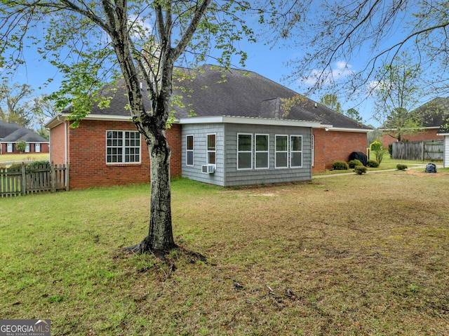 back of property with brick siding, roof with shingles, and cooling unit