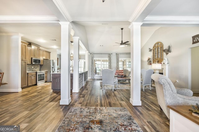 foyer with ceiling fan, decorative columns, dark wood finished floors, ornamental molding, and baseboards