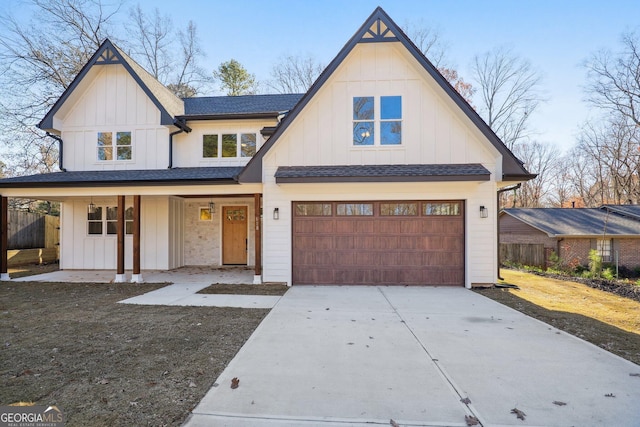 modern inspired farmhouse featuring a porch and a garage