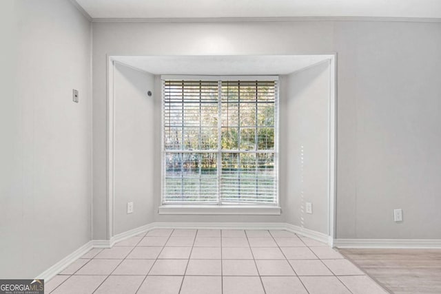 tiled spare room with crown molding