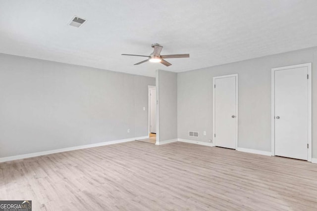 interior space featuring multiple closets, ceiling fan, and light wood-type flooring